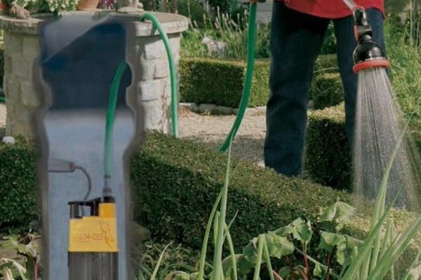 Bomba de agua para pozo utilizada para el riego de un jardín con manguera